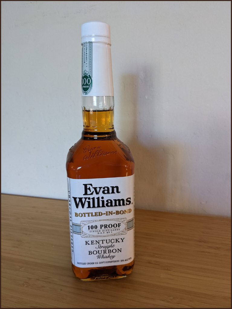 Evan Williams Bottled-In-Bond white label bottle on a light brown table with white wall background