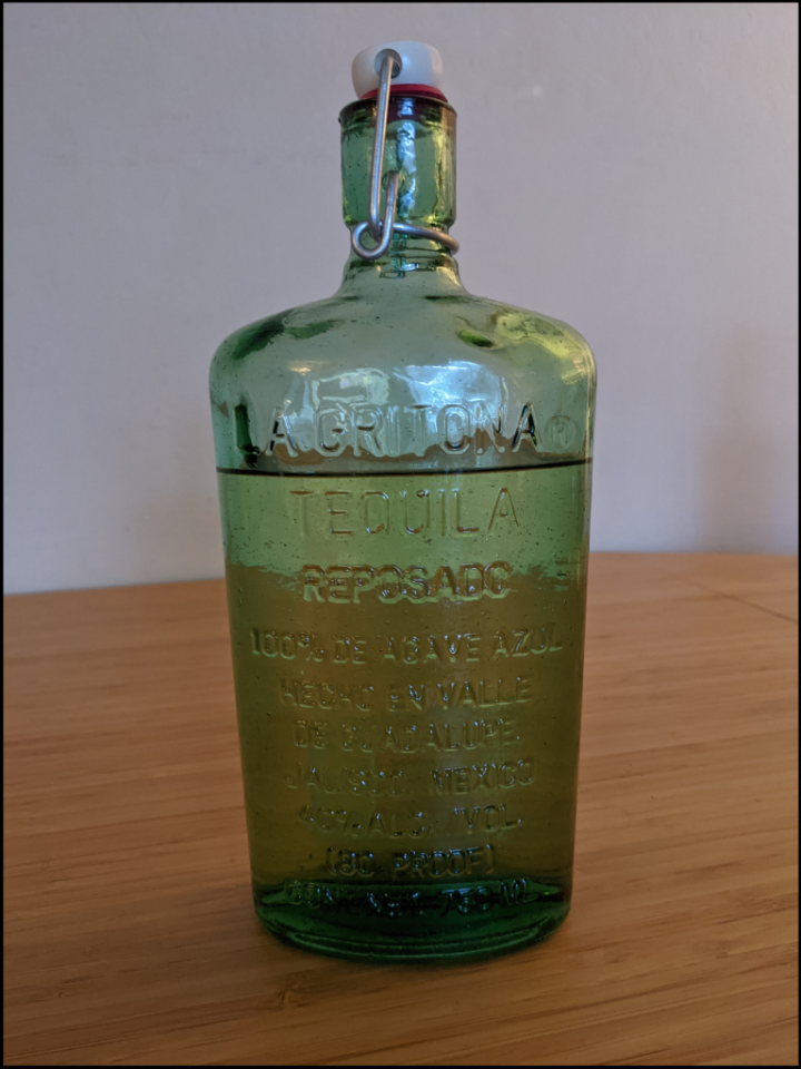 Green glass bottle with simple lettering embossed on the front