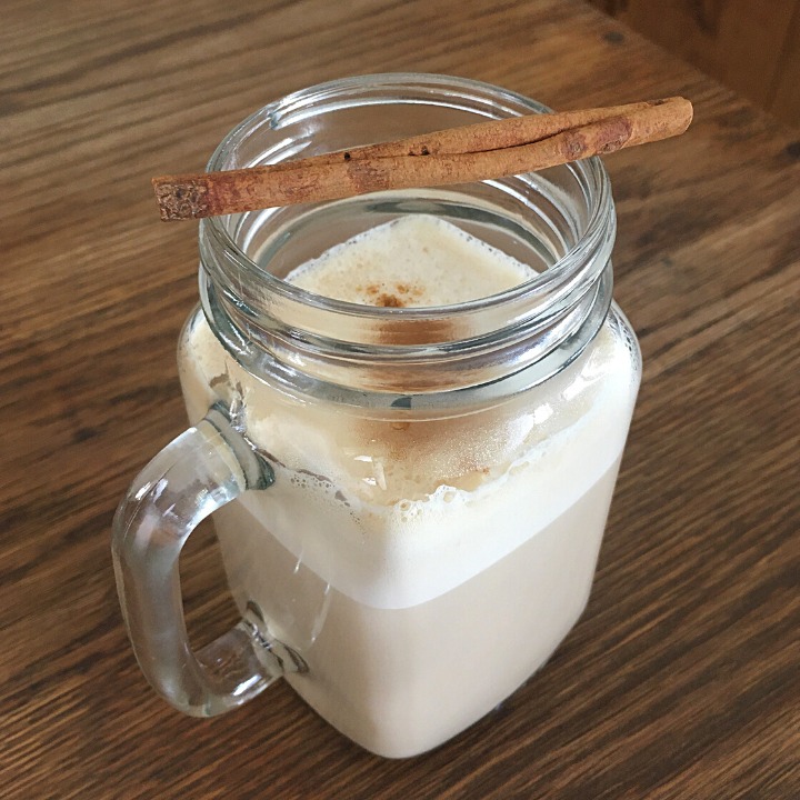 Coffee cocktail in a glass mug with a cinnamon stick garnish