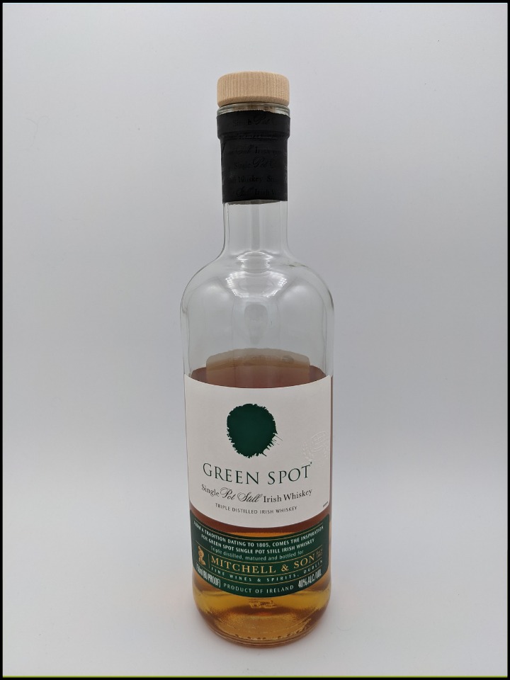 tall clear bottle of Green Spot Irish Whiskey with a green and white label with gold lettering