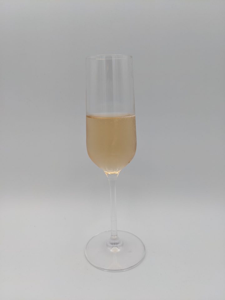 Pale gold liquid of Lapin Rouille Champagnein a long stemmed champagne flute