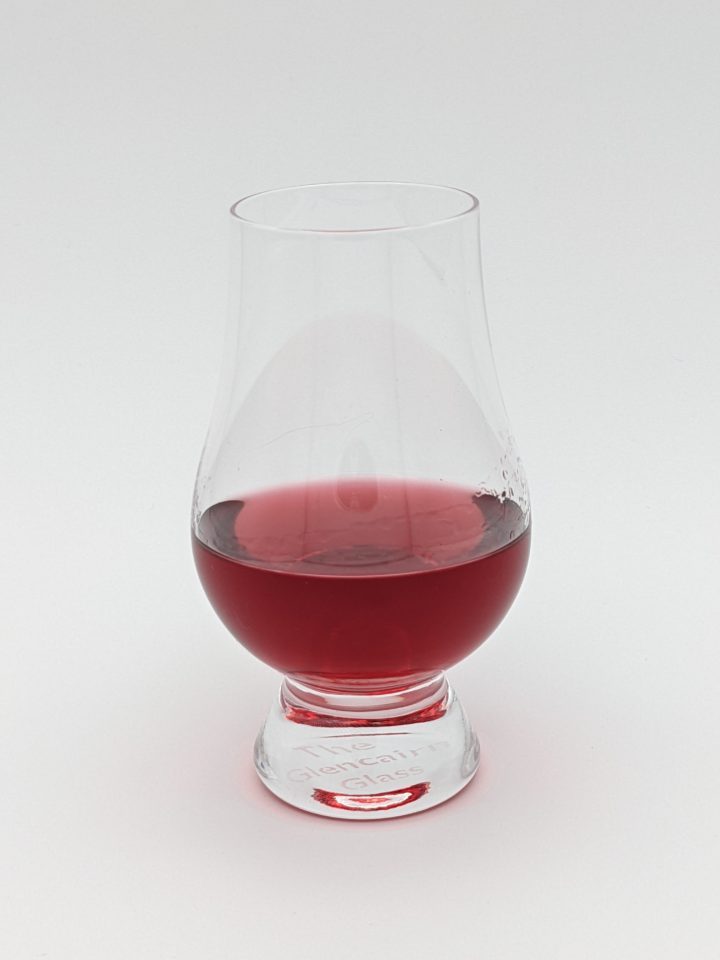 Ruby red liquid in a glencairn glass
