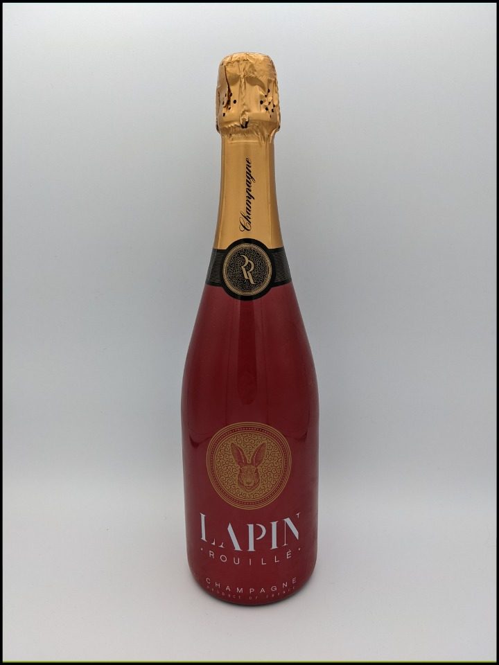 red champagne bottle of Lapin Rouille Champagne with gold lettering and rabbit logo with a gold and black top