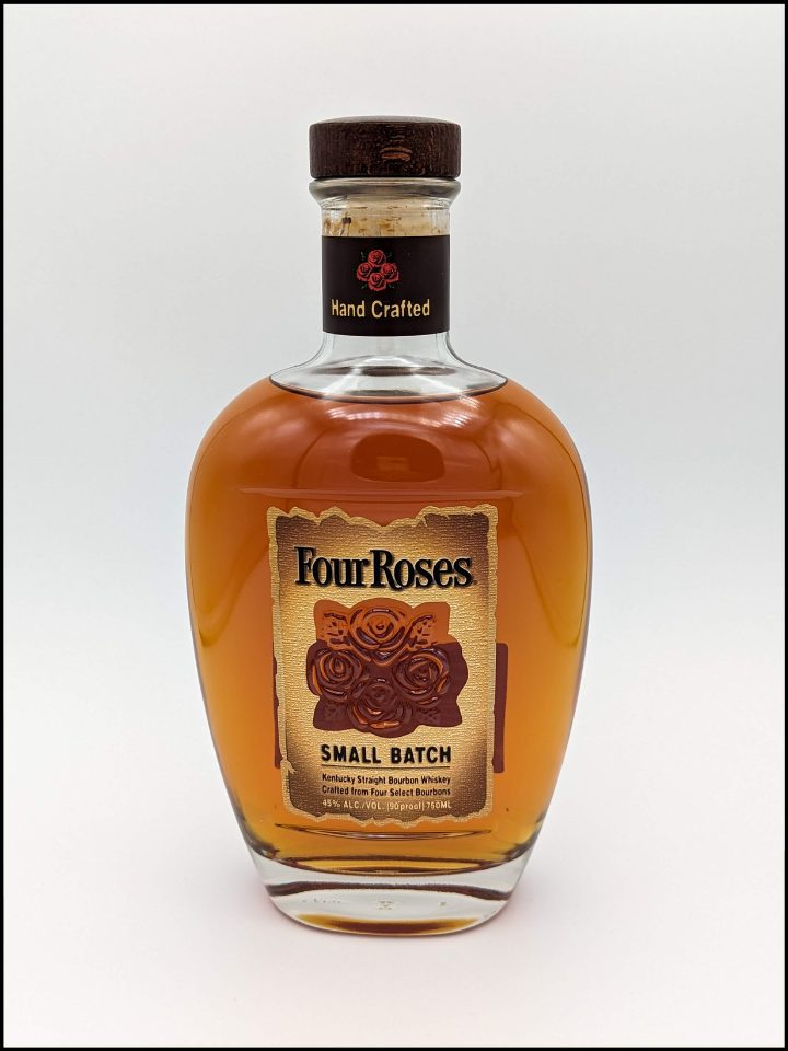 rounded bottles filled with caramel colored liquid with a light brown label with a red rose