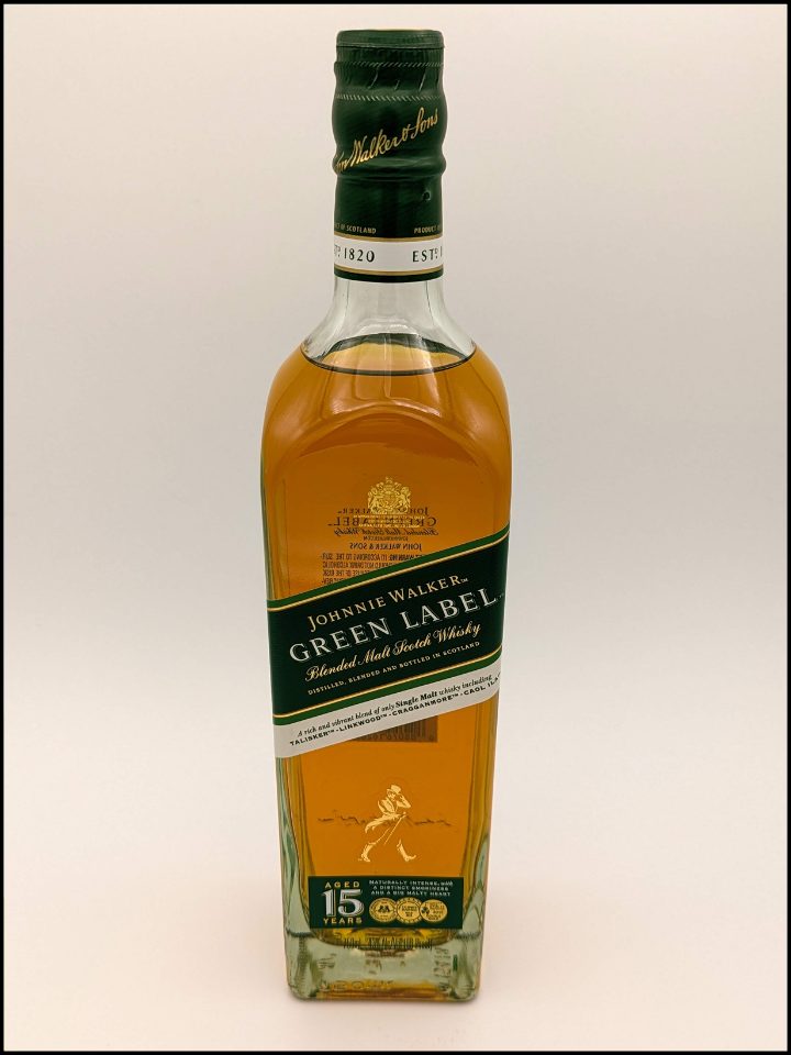 Tall bottle with a dark green label and green lettering filled with golden brown liquid