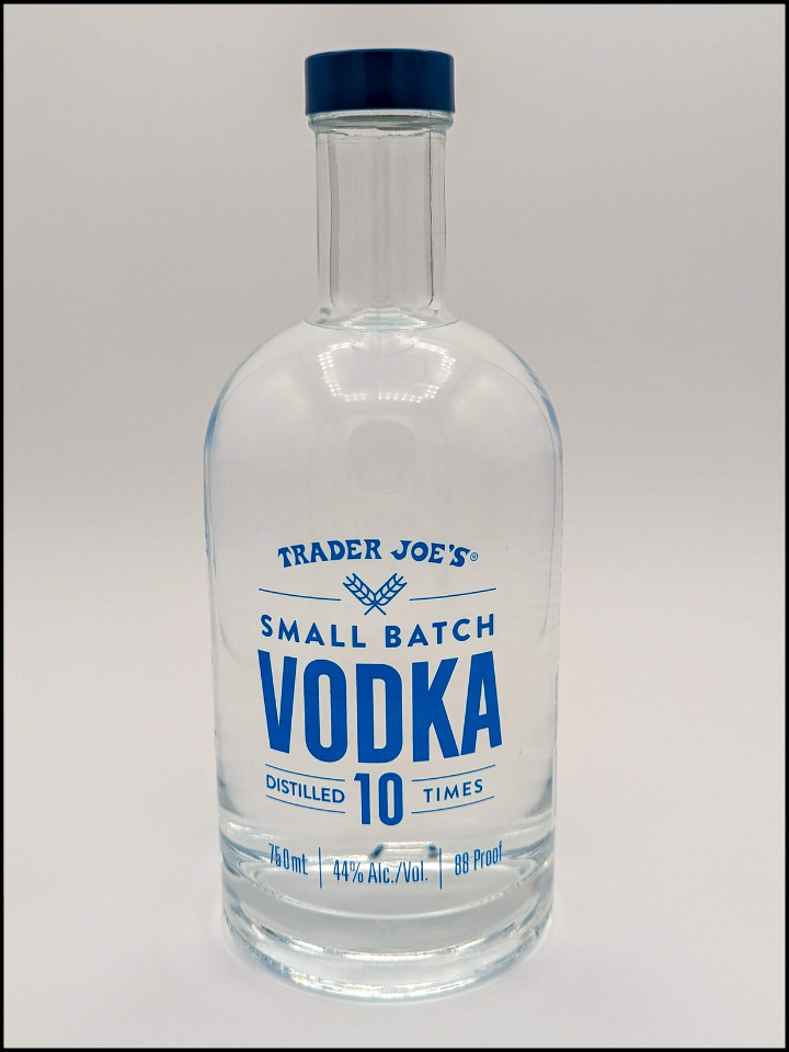 clear liquid in a rounded glass bottle with blue lettering that reads Trader Joe's Small Batch Vodka