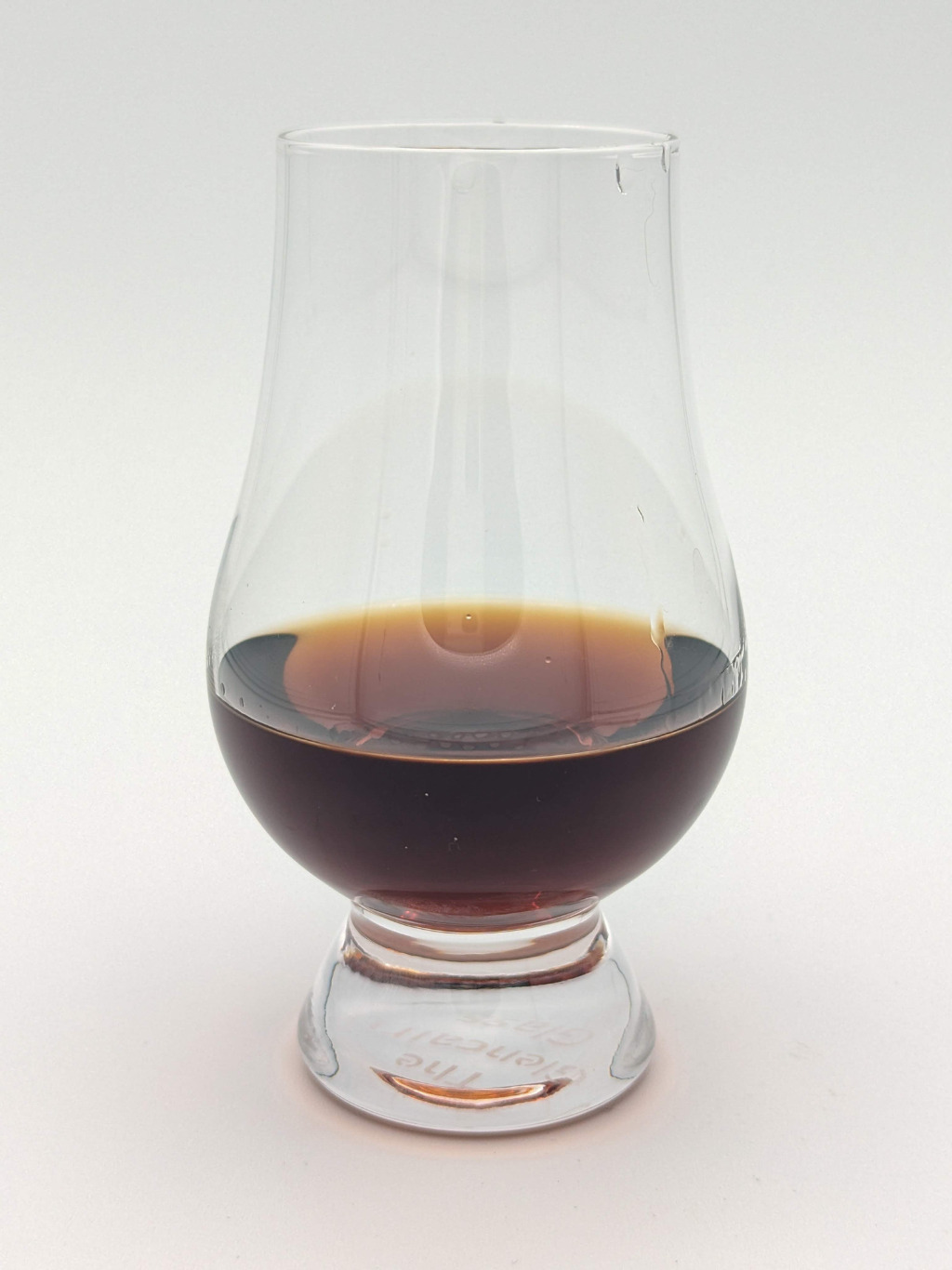 Dark brown liquid in a glencairn glass