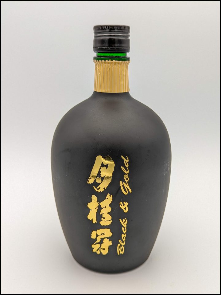 Round black bottle with gold lettering